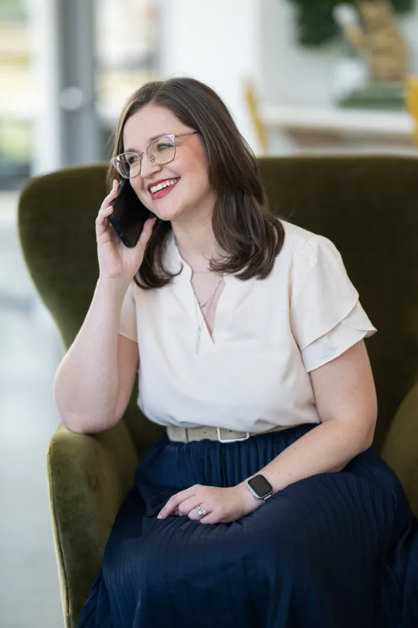 Allison on a call at her desk, notebook open.
